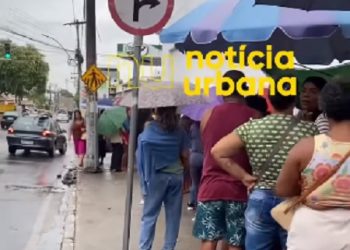 As vésperas do Natal e debaixo de chuva, campistas fazem fila para entrar em loja da cidade